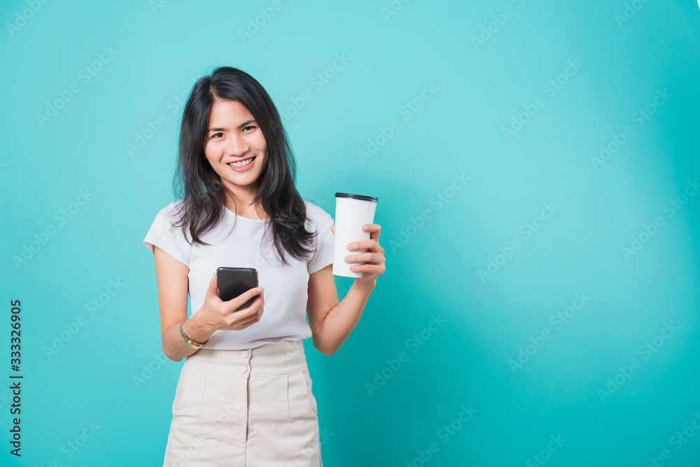 woman standing smile, using mobile phone her holding coffee paper cup woman standing smile, using mobile phone her holding coffee paper cup