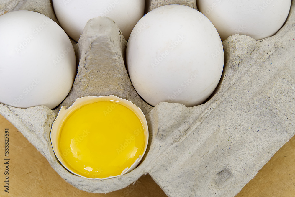 Paper Egg Tray with white eggs. chicken white eggs close up. broken chicken white egg. Paper Egg Tray with white eggs. chicken white eggs close up. broken chicken white egg.