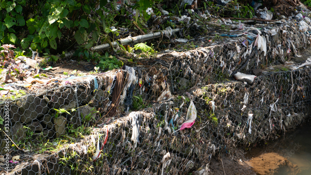 River bank with plastic garbage. It cannot be recycled and pollutes the environment River bank with plastic garbage. It cannot be recycled and pollutes the environment