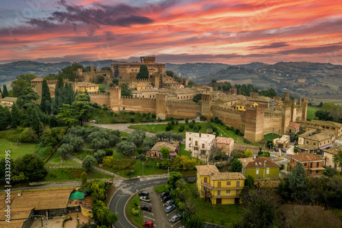 Aerial sunset view of the walled town and castle of Gradara in Marche Italy popular tourist destination of the well preserved double walls and castle with red, orange sky photo
