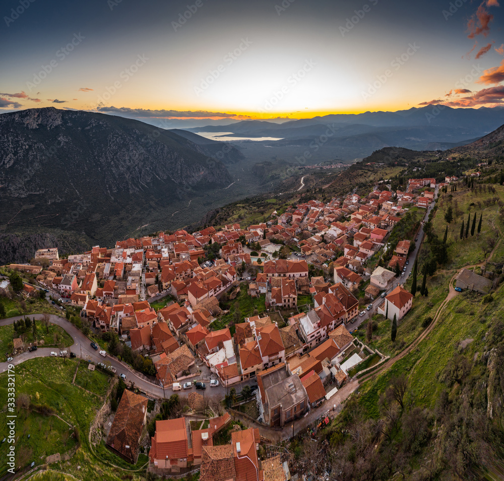 Φωτογραφία Aerial view of Delphi, Greece, the Gulf of Corinth, orange color of clouds, moun