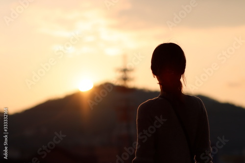 夕陽を眺める女性