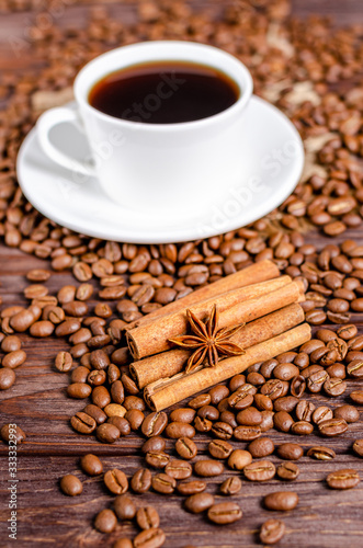Anise star on cinnamon sticks with roasted arabica coffee beans on wooden background.