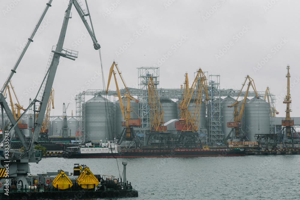 grain elevator in the seaport of Odessa against the background of unloading and loading cranes