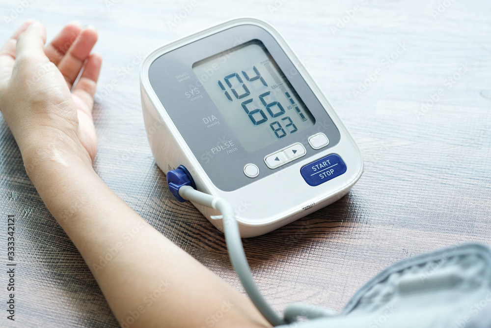Man check blood pressure monitor and heart rate monitor with digital pressure gauge. Health care and Medical concept Man check blood pressure monitor and heart rate monitor with digital pressure gauge. Health care and Medical concept
