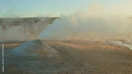 Steam Expelling Out On The Sand Under The Blue Sky With A Vast Field In The Background. -medium shot photo