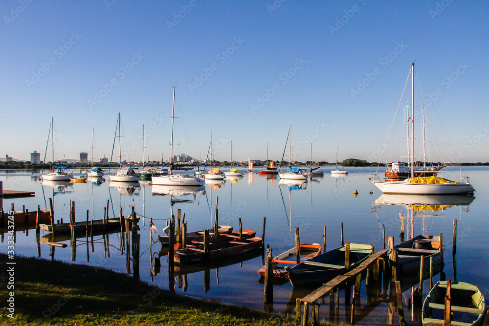 Obraz premium Boats and their reflections in the sea water.