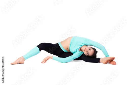 Beautiful woman gymnast in a tight fit tights doing twins and smiling on a bright white isolated background. The concept of gymnasts and sports stretching, oriental relaxation practices