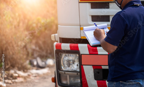 Truck drivers hand holding clipboard Check the product list,Preforming a pre-trip inspection on a truck,spot focus.