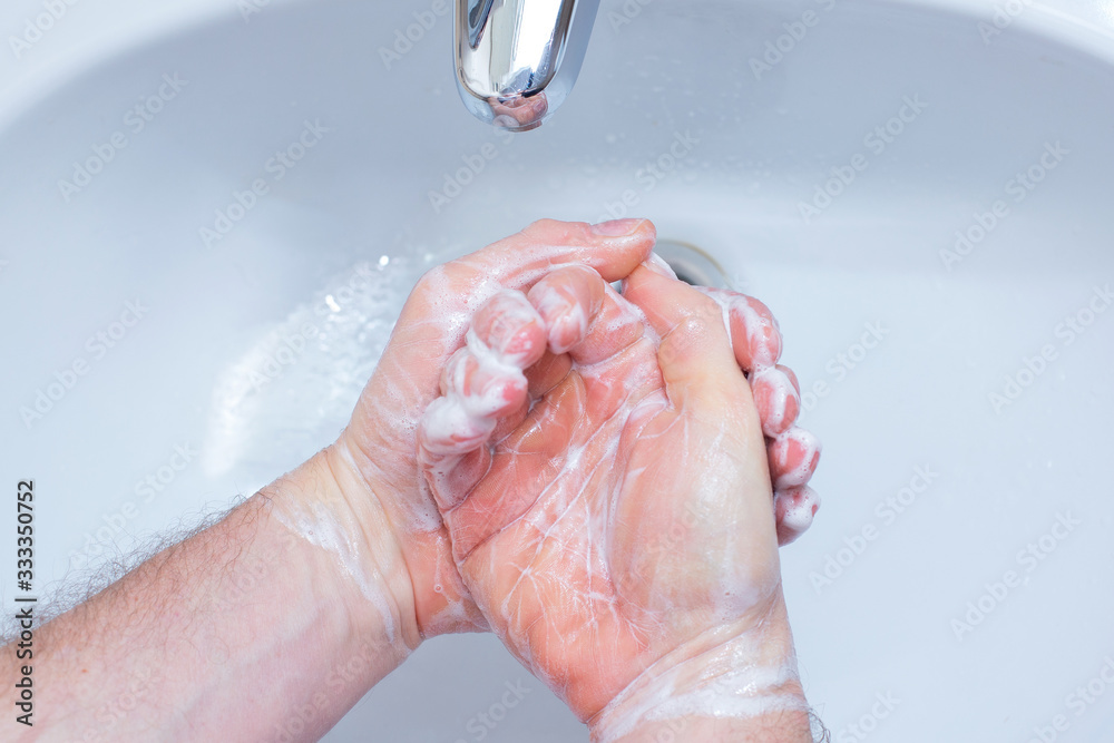 A Man is washing his hands with soap in bathroom. A Man is washing his hands with soap in bathroom.