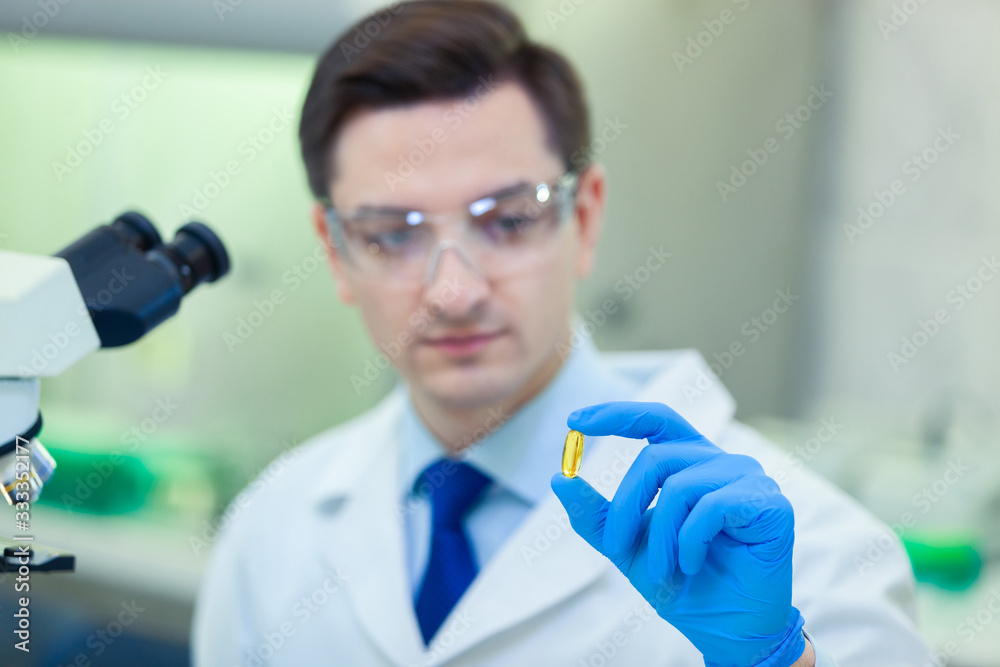 Scientist studies properties and benefits of omega 3 fatty acids using microscope and laboratory equipment in a medical laboratory. COVID-19. COVID Coronavirus Scientist studies properties and benefits of omega 3 fatty acids using microscope and laboratory equipment in a medical laboratory. COVID-19. COVID Coronavirus