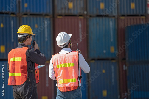 Foreman control loading containers box from cargo freight ship for import export, Foreman control industrial container cargo freight ship, Business import and export logistic concept.