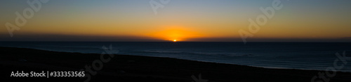 The last rays of a setting sun as it falls below the ocean horizon © Andrew