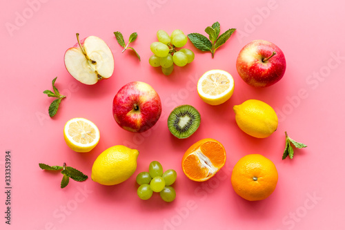 Colorful fruit pattern. Cut apple  kiwi  citrus on pink background top-down