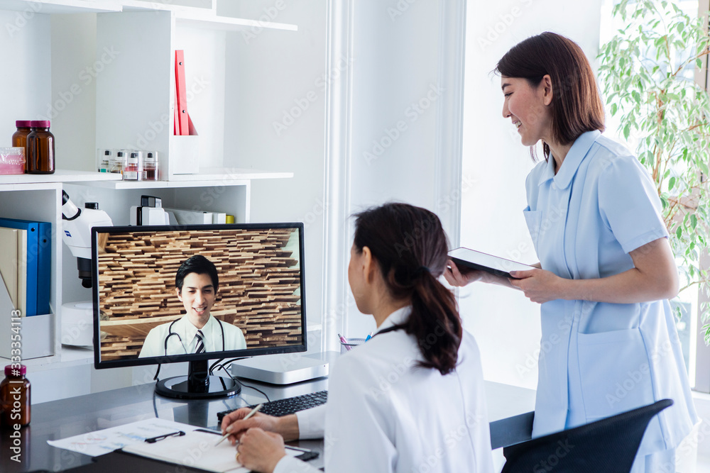 Fototapeta premium 海外の医師とビデオ会議をする女性医師と看護師
