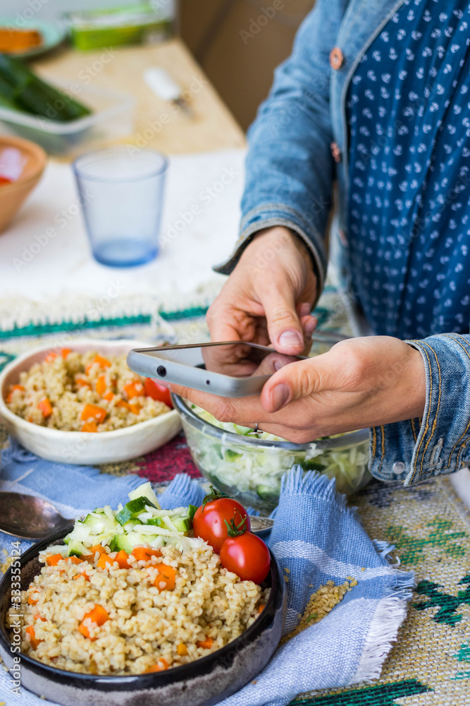 Smartphone food photography. Phone photo picture of bulgur tabbouleh with vegetables. Food order service concept for social media blogging. Vegan, vegetarian meal.
