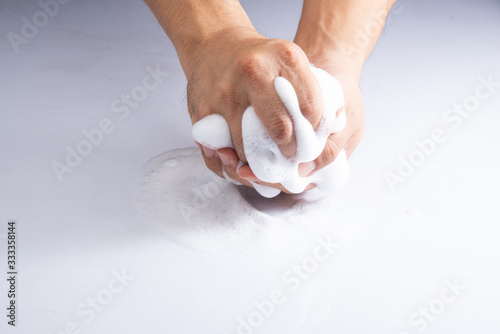 scrubbing hand by soap or cleasing oil on white acrylic sheet background