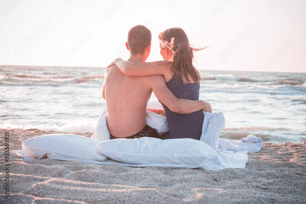 couple sitting on the beach and looking into the distance