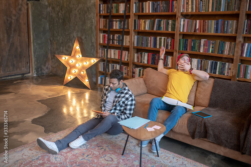 Two young men studying before exams and feeling tired photo