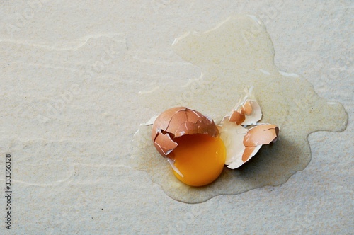 ฺBroken egg on the floor with copy space. Selective focus. This photo can be used for the concept of how to clean up the dropped eggs.