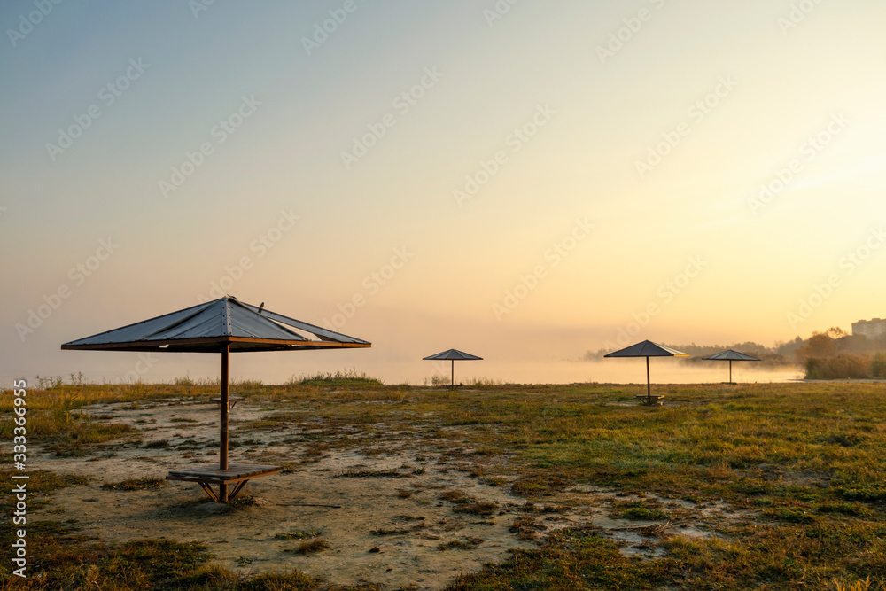 foggy dawn on the beach with umbrellas