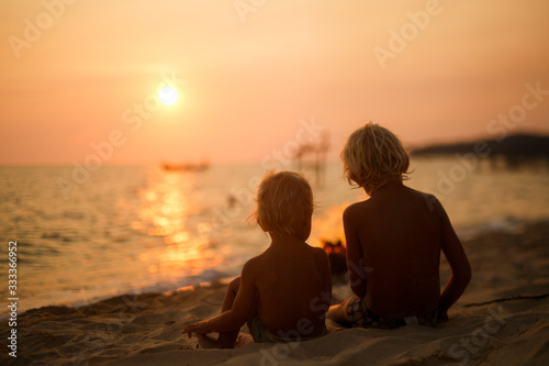 children at sunset by the sea