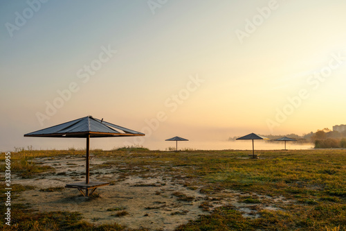 foggy dawn on the beach with umbrellas