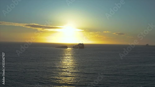 Aerial drone push in shot of the sunset falling between the rocks in the ocean at San Simeon California USA photo