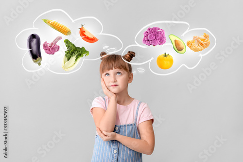 Thoughtful little girl on light background