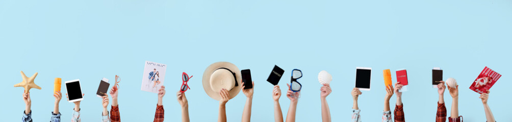 Many hands with travel items on color background