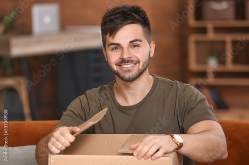 Young man unpacking parcel ...