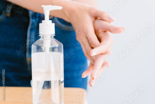 Woman rubbing hand with alcohol disinfection solution. With copy space.