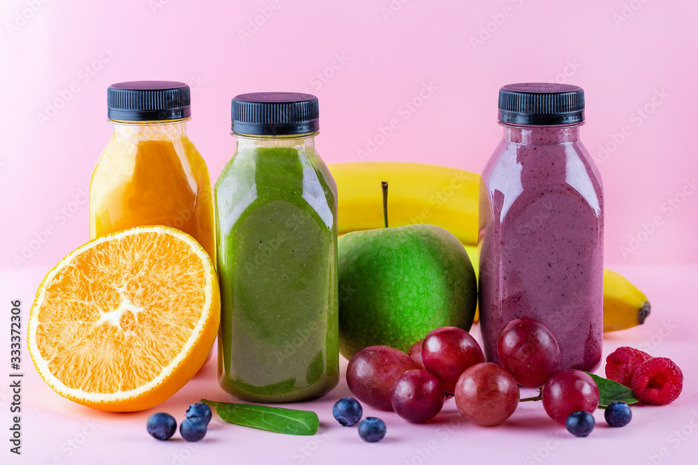 Colourful healthy smoothies and juices in bottles on color background with copy space. Colourful healthy smoothies and juices in bottles on color background with copy space.