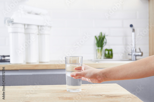 Female Hand holding a glass of clean water. Purified water and healthy life concept.