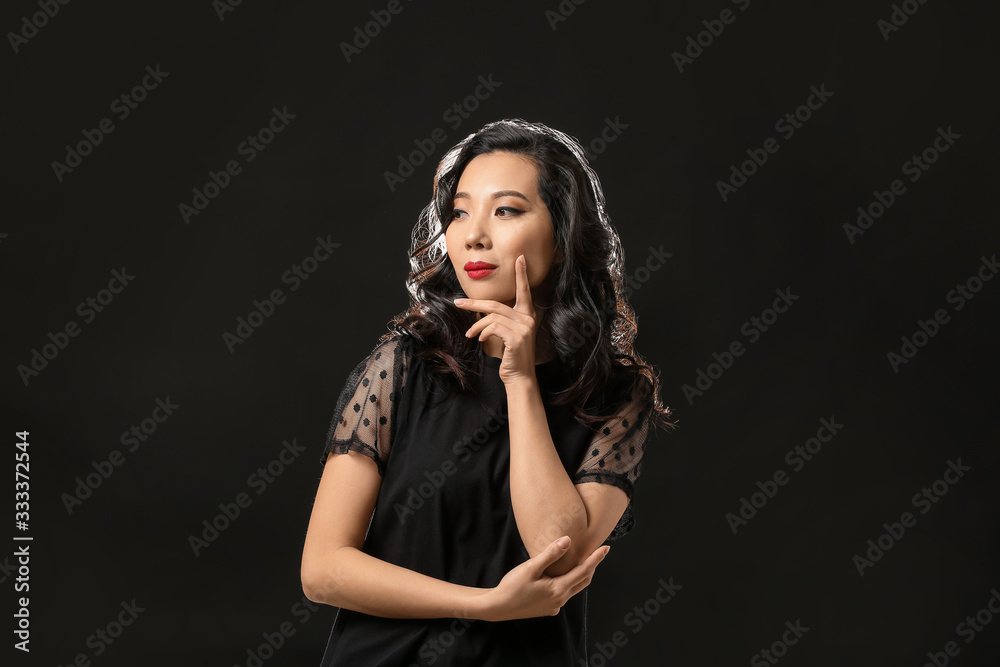 Young Asian woman with beautiful hair on dark background Young Asian woman with beautiful hair on dark background