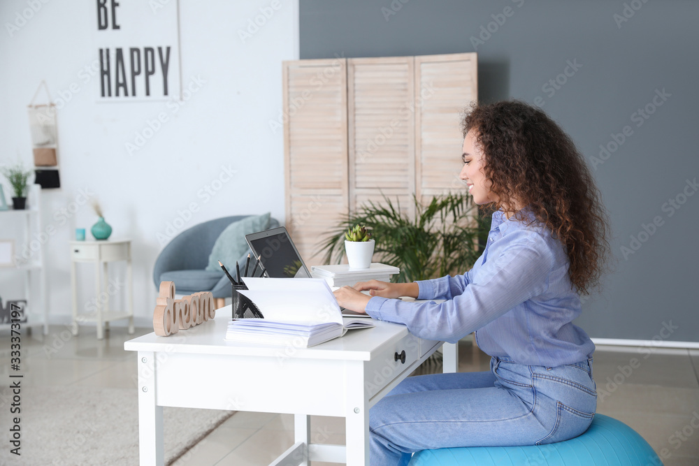 © Pixel-Shot - Woman sitting on fitness ball while working at home © Pixel-Shot - Woman sitting on fitness ball while working at home