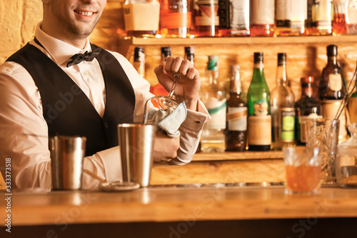 Male bartender wiping glass...