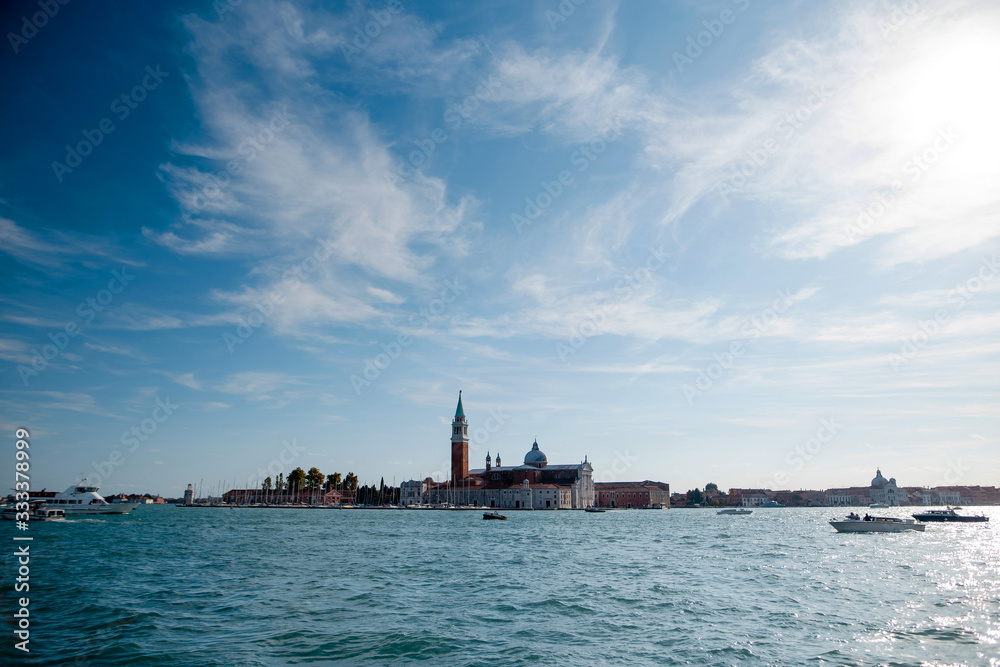 View of the blue turquoise Venice lagoon with Campanile in the background. Trip to Italy. Blue sky and sunny day