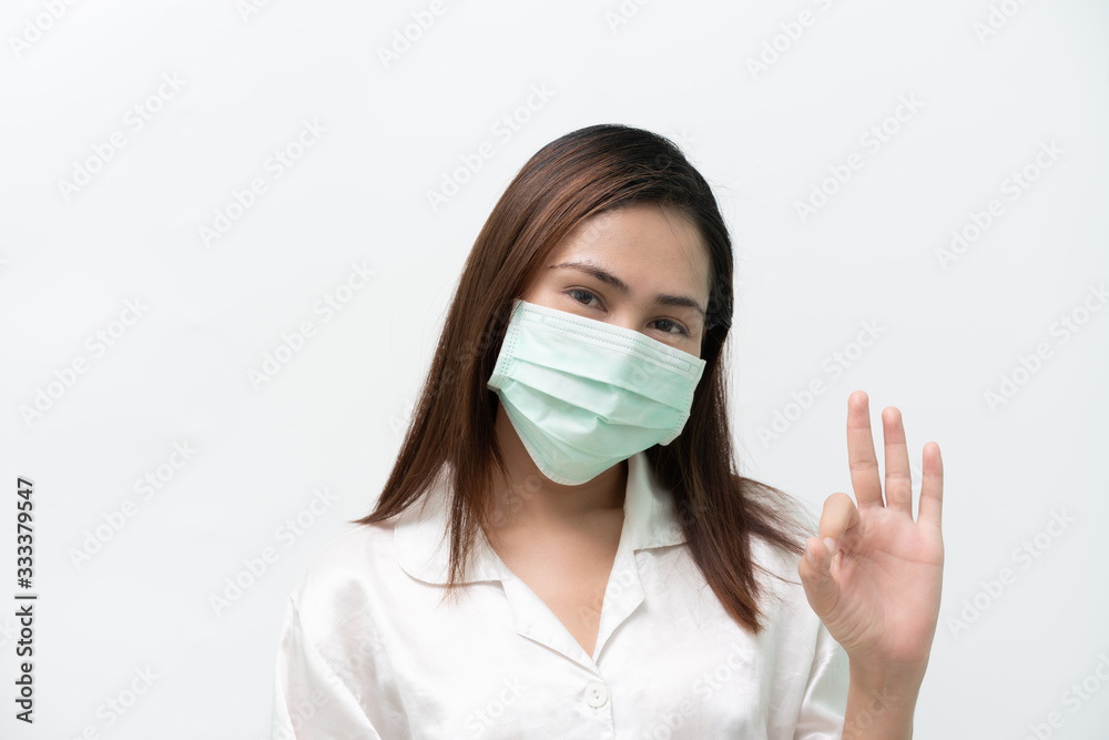 White shirt wearing a medical mask to prevent the flu and the covid-19 corona virus and ok symbol White shirt wearing a medical mask to prevent the flu and the covid-19 corona virus and ok symbol