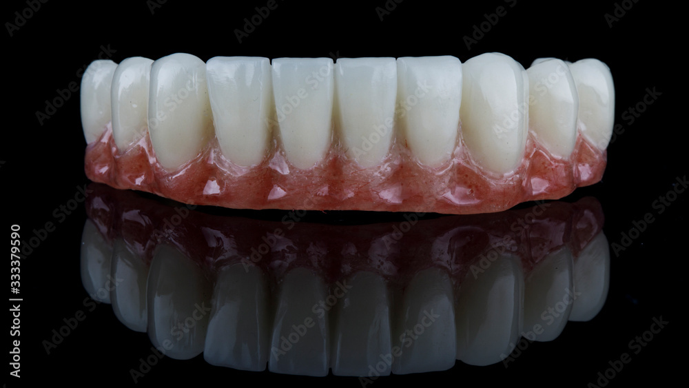 excellent macro photo of a dental lower jaw prosthesis on black glass excellent macro photo of a dental lower jaw prosthesis on black glass
