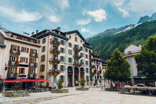 Beautiful square with street cafe in sunny day, Chamonix, France. Travel and rest concept. Typical street view with mountain landscape