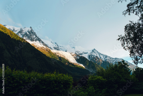 Wonderful landscape in Chamonix. Snowy mountains in sunny day. Forest and blue sky. Alps, France