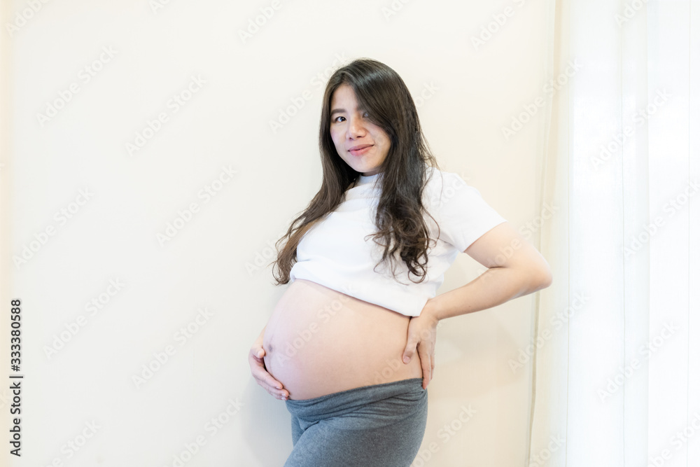 Pregnant woman feeling happy at home while taking care of her child. Maternity prenatal care and woman pregnancy concept. Pregnant woman feeling happy at home while taking care of her child. Maternity prenatal care and woman pregnancy concept.