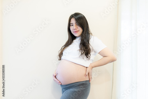 Pregnant woman feeling happy at home while taking care of her child. Maternity prenatal care and woman pregnancy concept. Free Download Pregnant woman feeling happy at home while taking care of her child. Maternity prenatal care and woman pregnancy concept. - GFXLoad