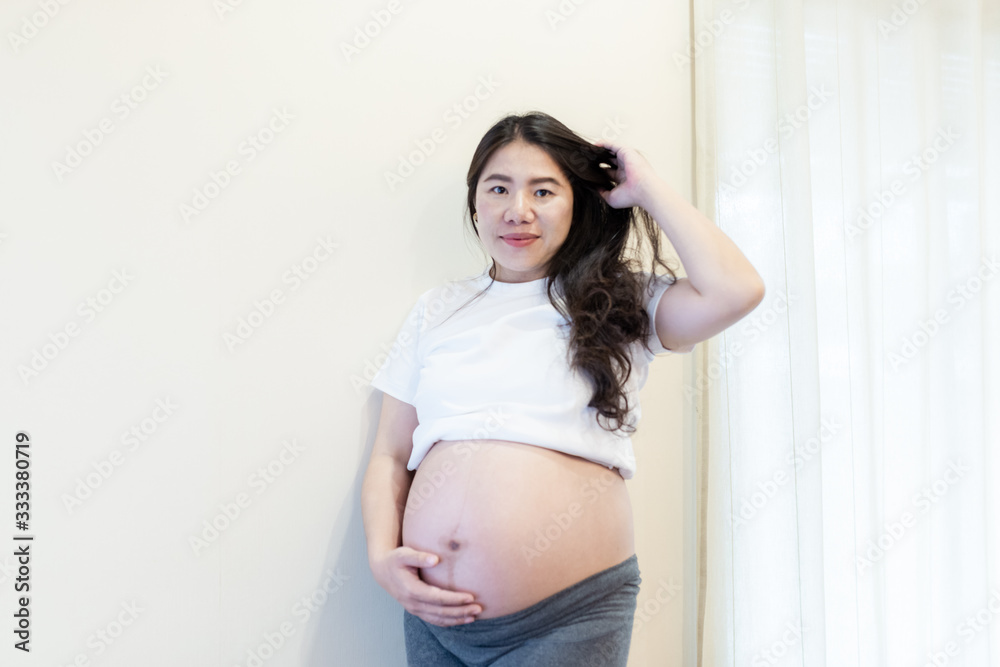 Pregnant woman feeling happy at home while taking care of her child. Maternity prenatal care and woman pregnancy concept. Pregnant woman feeling happy at home while taking care of her child. Maternity prenatal care and woman pregnancy concept.