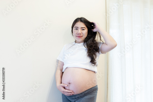 Pregnant woman feeling happy at home while taking care of her child. Maternity prenatal care and woman pregnancy concept. Free Download Pregnant woman feeling happy at home while taking care of her child. Maternity prenatal care and woman pregnancy concept. - GFXLoad