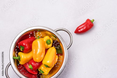 Ripe Small Red and Yellow Peppers in Bowl Light Gray Background Vegetable