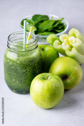 Glass Jar of Healthy Green Smoothie Detox Drink wirh Green Apple Celery and Raw Spinach Diet Beverage Vertical