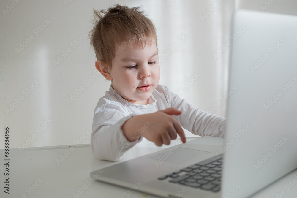 Toddler boy working, learning trough laptop online. distance education concept. Home isolation quarantine Toddler boy working, learning trough laptop online. distance education concept. Home isolation quarantine