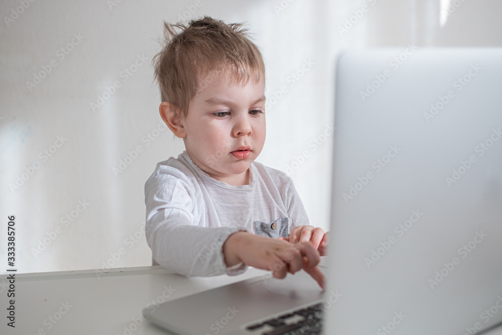 Toddler boy working, learning trough laptop online. distance education concept. Home isolation quarantine Toddler boy working, learning trough laptop online. distance education concept. Home isolation quarantine
